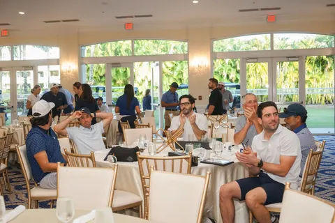 Attendees sit together at tables in the reception room.